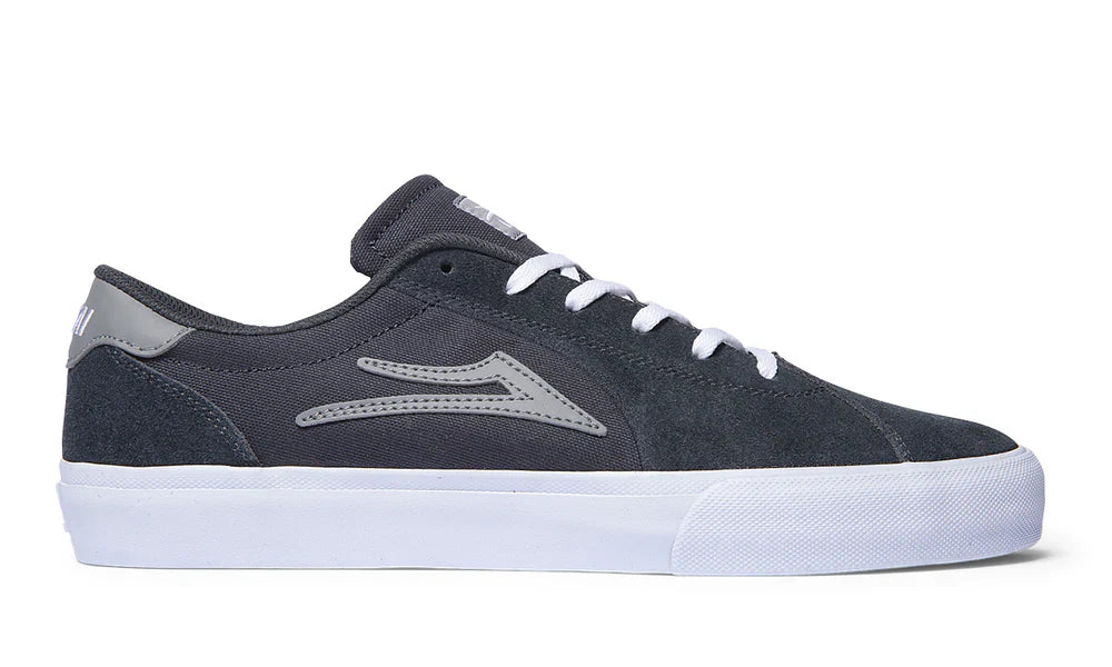 Black suede Flaco II shoe with white sole and grey logo, featuring advanced cushioning and flexible tread design.