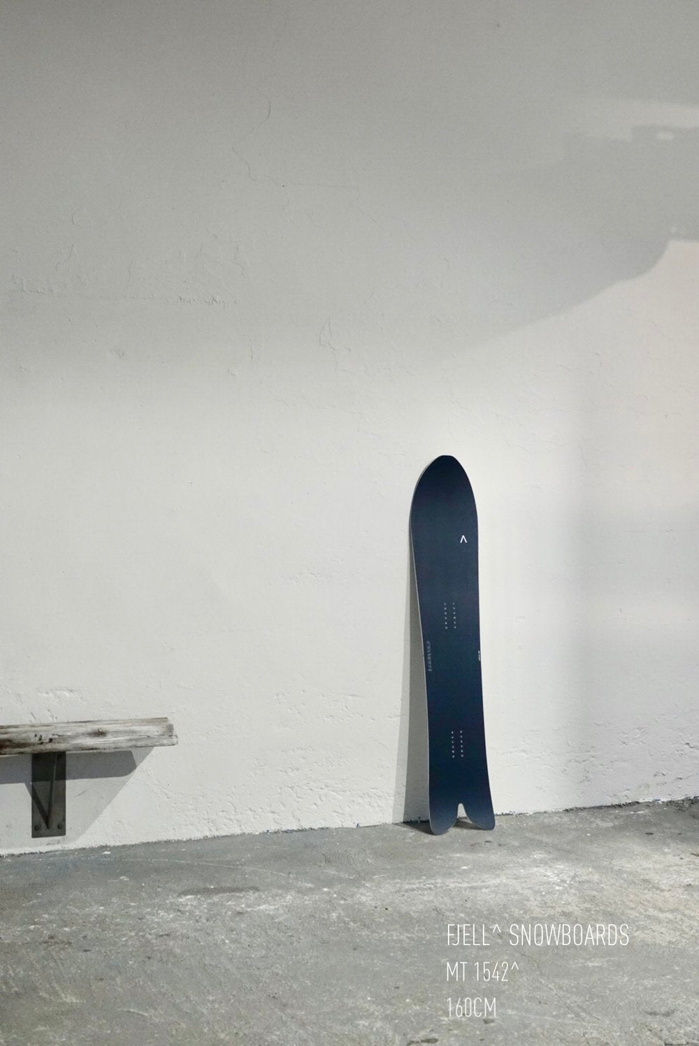 FJELL MT1542 snowboard with directional shape and S rocker base, leaning against a wall.