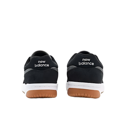 Black NM480MGC shoes with gum sole, back view showing New Balance logo.